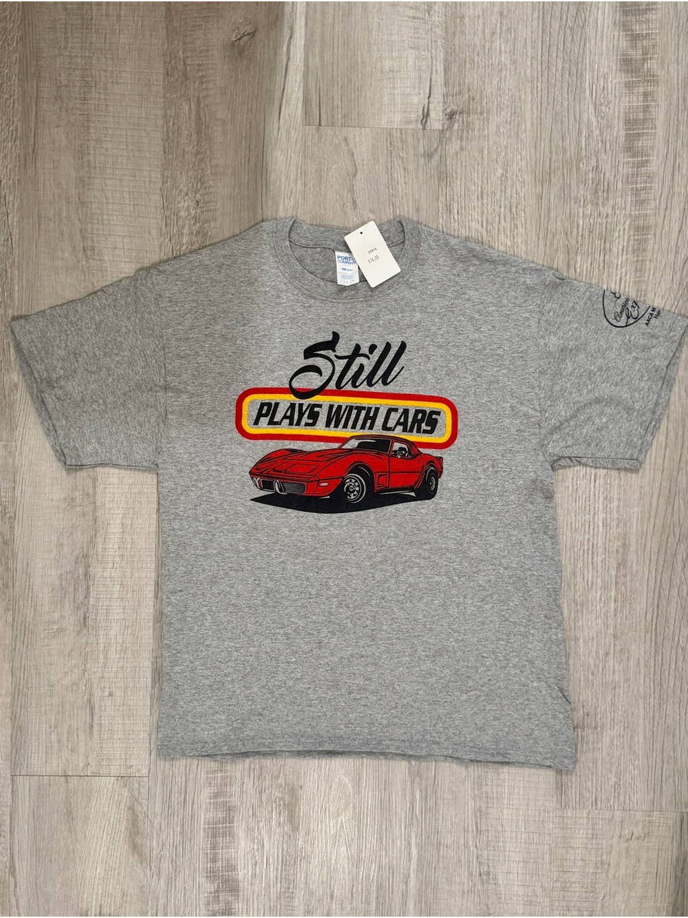 New Grey AACA Museum Tee with red Corvette Graphic and “Still Plays With Cars”